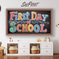 Decorative sign for the first day of school with colorful text in a home setting.